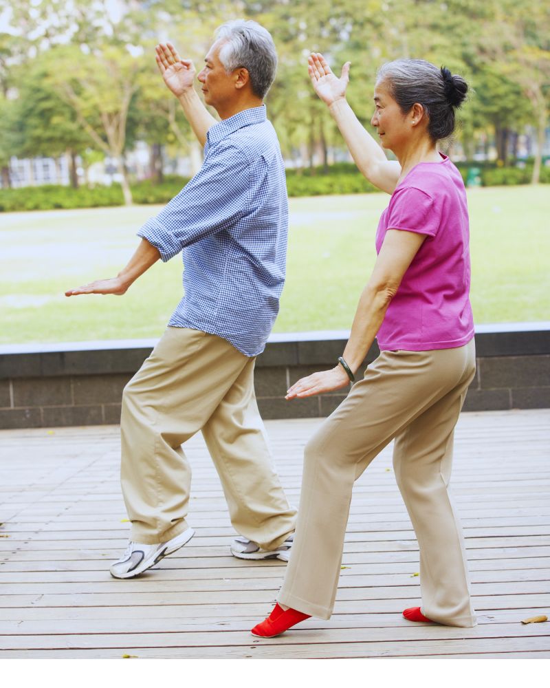 a man and woman doing tai chi after discovering the best hobbies for couples over 50