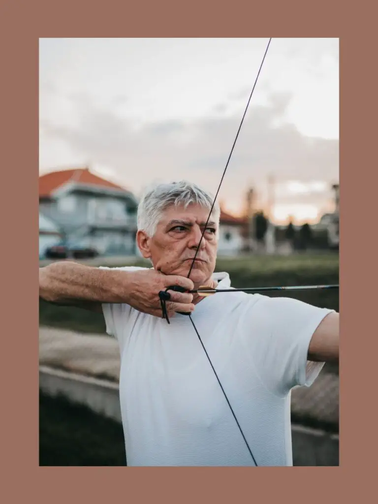 a man holding a bow and arrow practicing for competitive sports for adults over 50