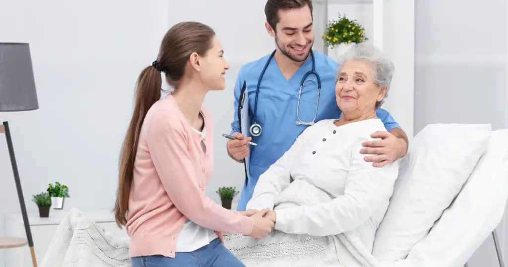 a woman holding a woman's hand in a twin adjustable bed for seniors.