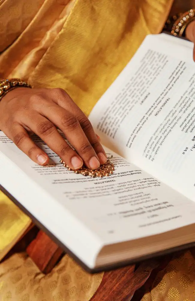 A hand on a book from a member of a book club, one of many hobbies for people over 50.