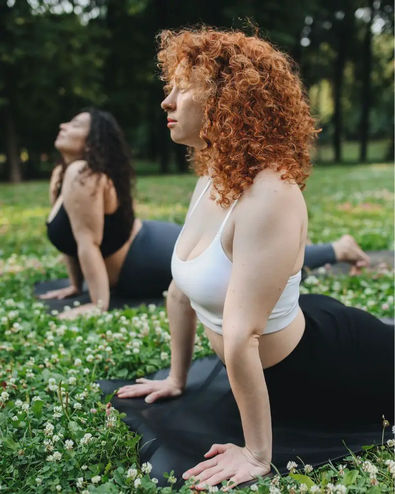 a group of women doing yoga and demonstrating the cobra pose as a safe stretch for over 50 people