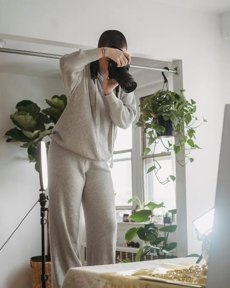 a woman taking a picture of a plant as part of a side hustle for people over 50