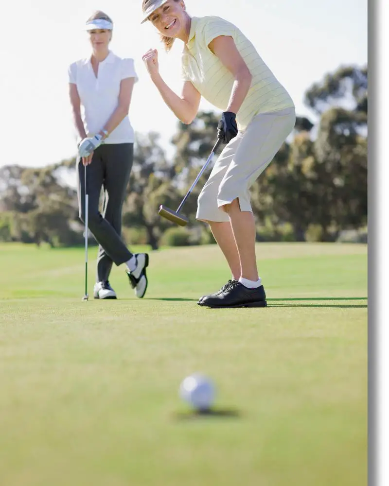 a woman playing golf on a golf course while showing off their women's golf attire etiquette.