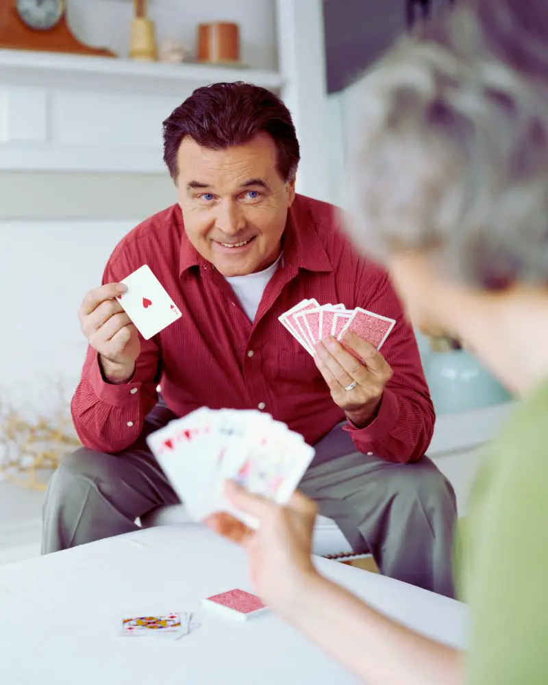 a man holding a deck of cards to demonstrate one of many hobbies for men over 60