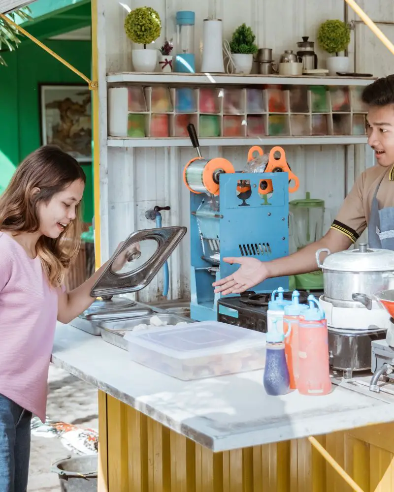 A woman standing at a small business craft stand talking about an easier way to navigate the tax season.