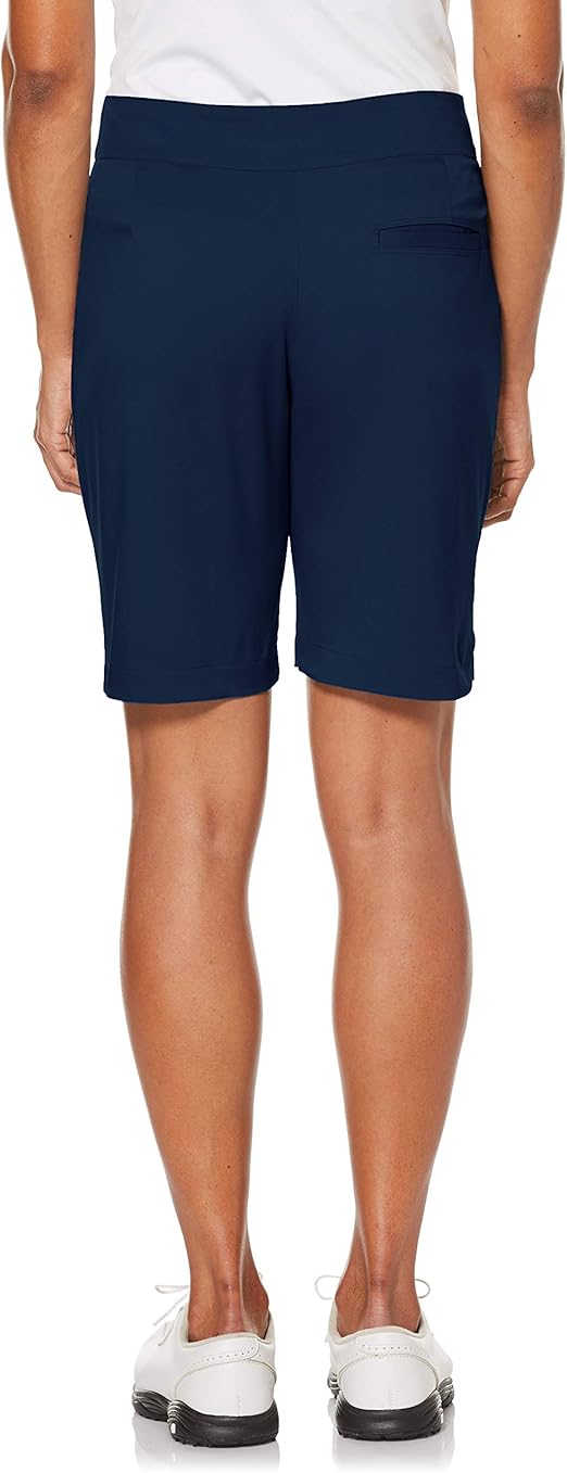 Woman wearing knee length navy blue golf shorts to demonstrate women's golf attire etiquette.