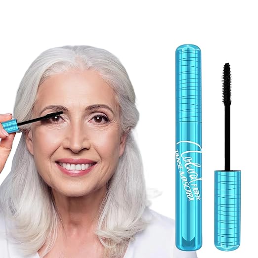 A woman with white hair applying the best mascara for people over 50