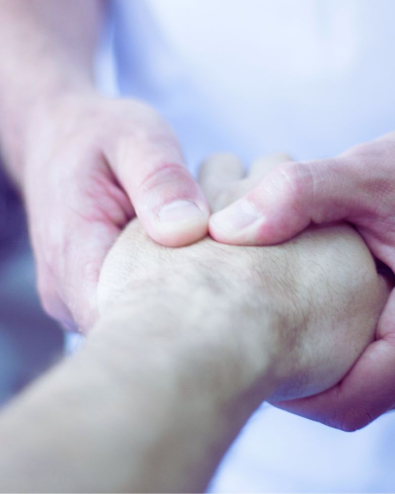 a close-up of a person's hand being treated by a physio therapist