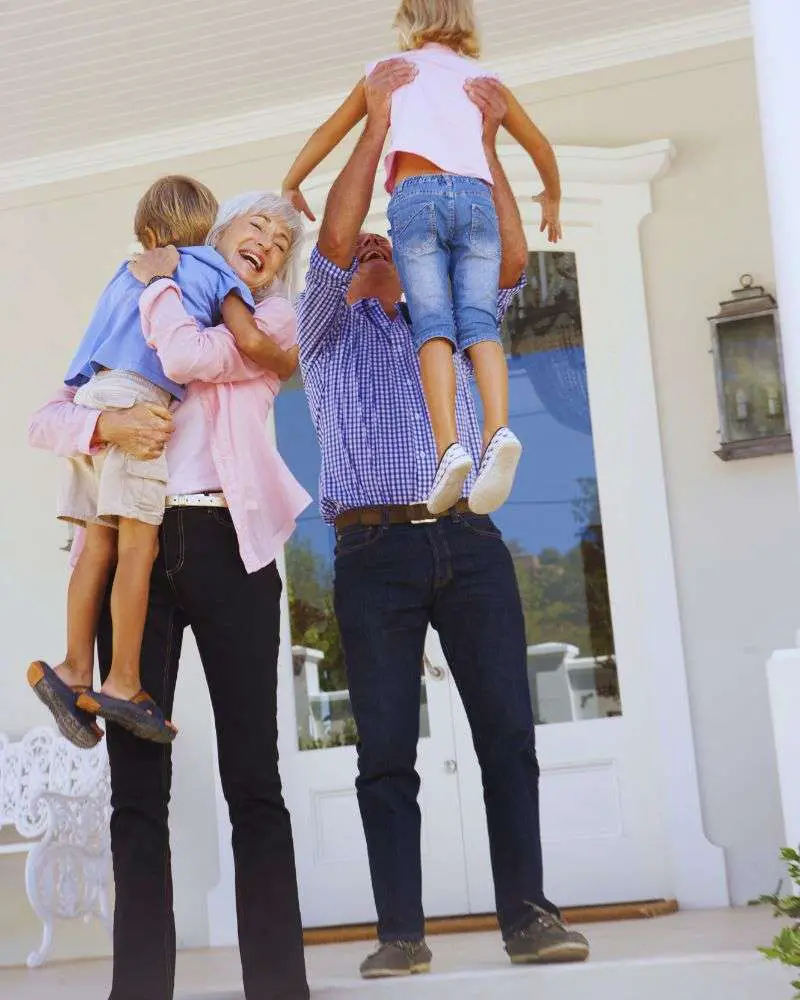 Grandparents holding their grandkids in the air wondering how to say no to watching the grandkids 