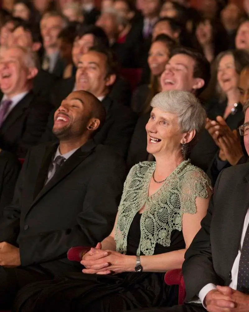 a group of people laughing with someone who learned how to write a retirement speech.