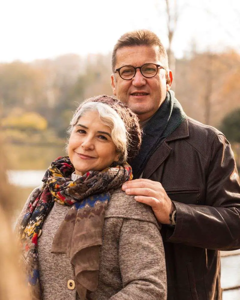 a man and woman standing together wondering how to know if a man over 50 likes you