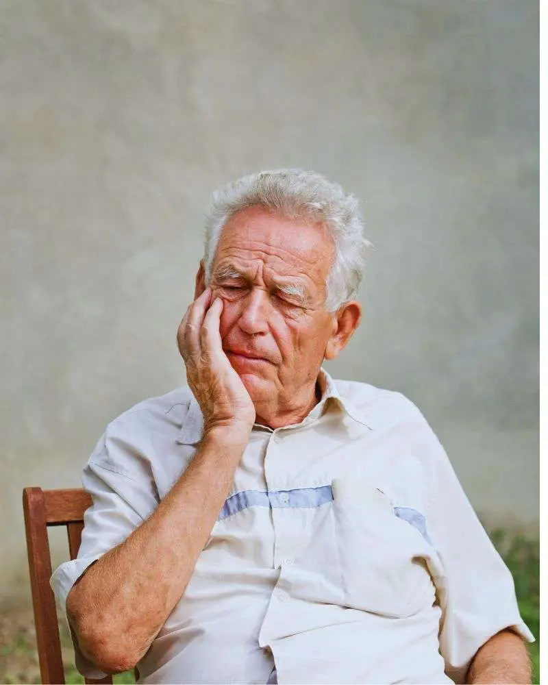 an old man with his hand on his face wondering what not to say to someone with dementia