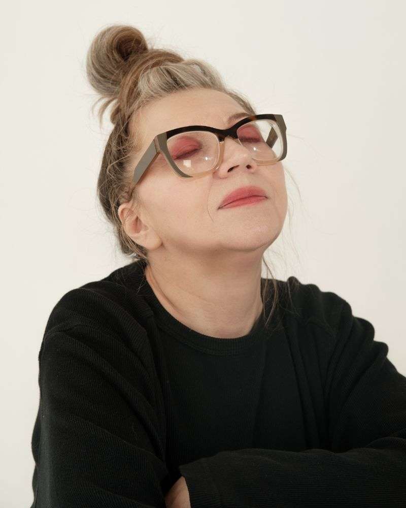 a woman wearing glasses and a black shirt