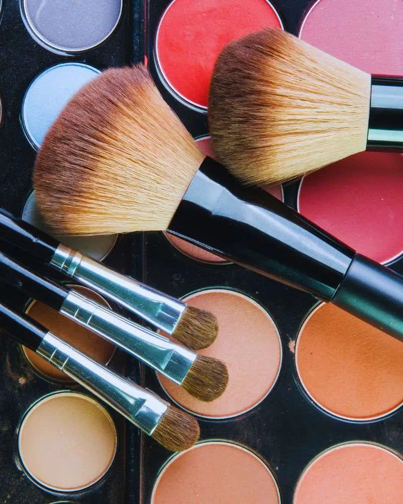 a group of brushes on a palette of makeup that are reviewed by beauty bloggers over 50