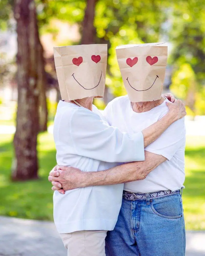 two people hugging each other with bags on their faces