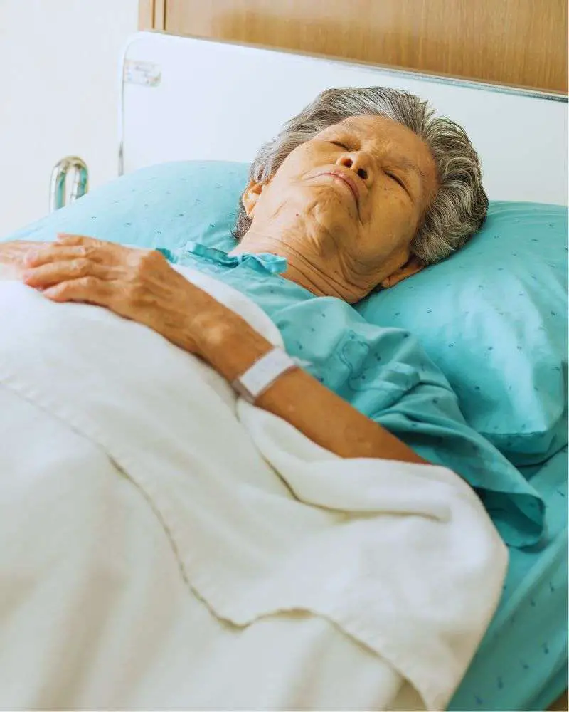 a woman lying in a hospital bed and whose family is likely asking how long do hospice patients live without eating