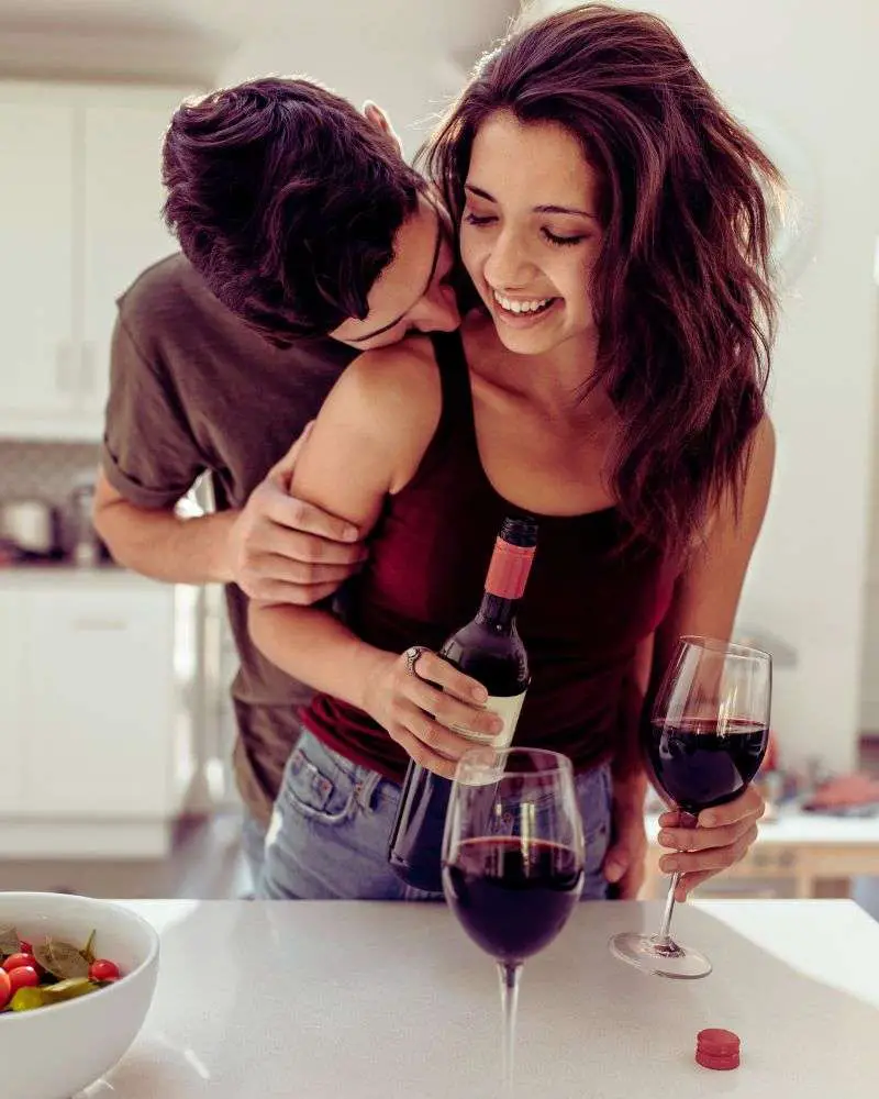 a man and woman holding wine glasses and smiling