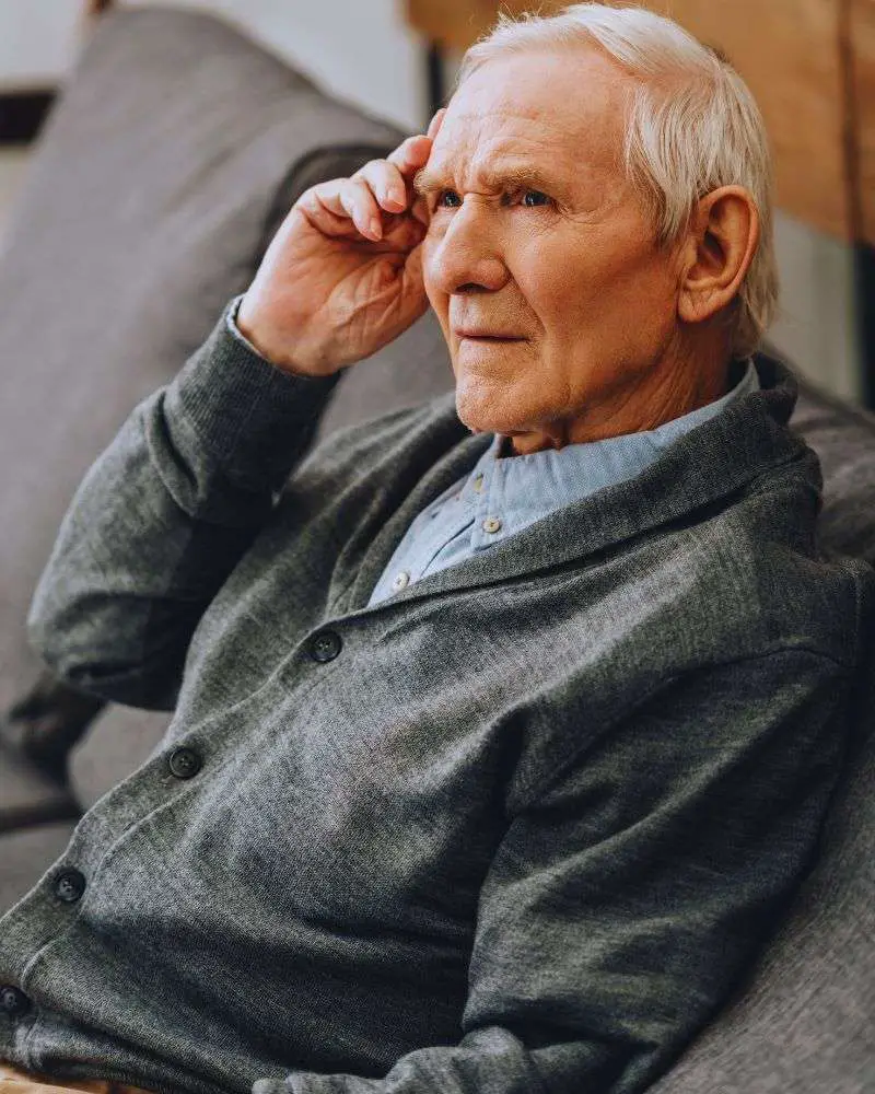 an old man sitting on a couch wondering what not to say to someone with dementia