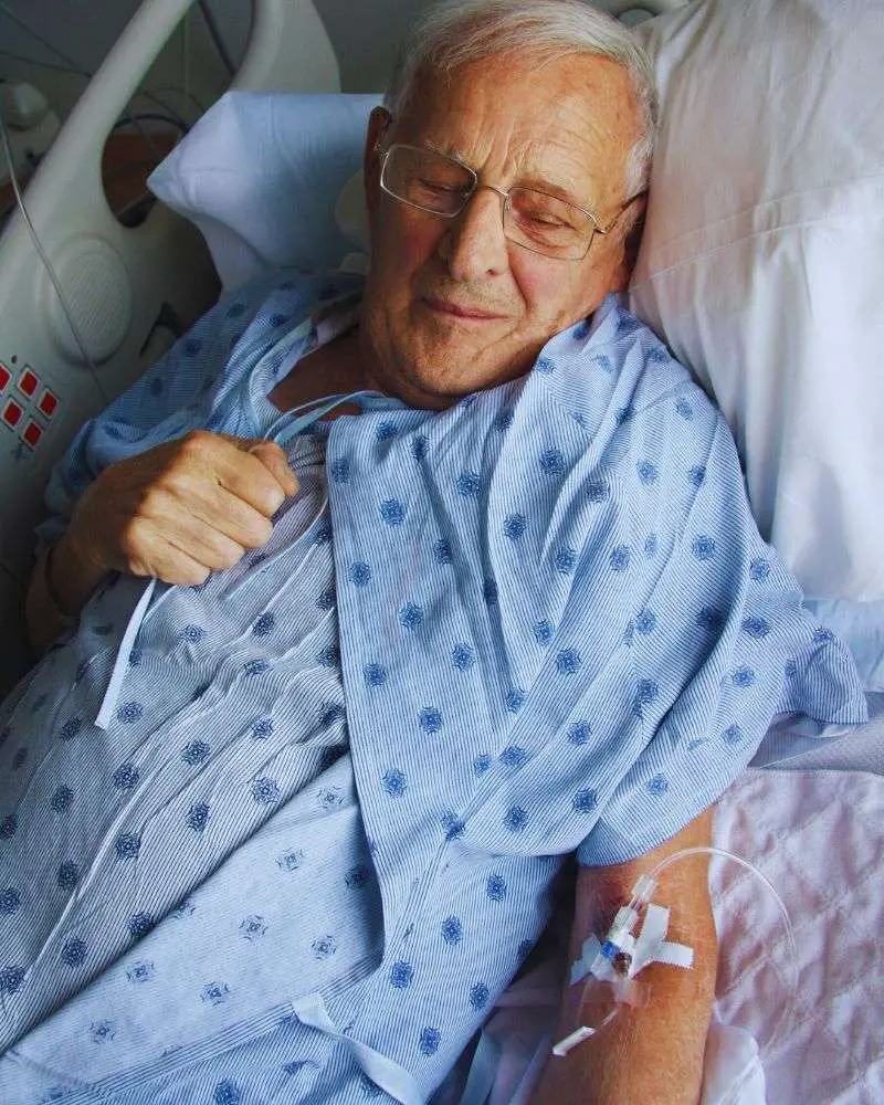 a man in a hospital bed who is in the natural phase of dying while is family is likely asking how-long-do-hospice-patients-live-without-eating