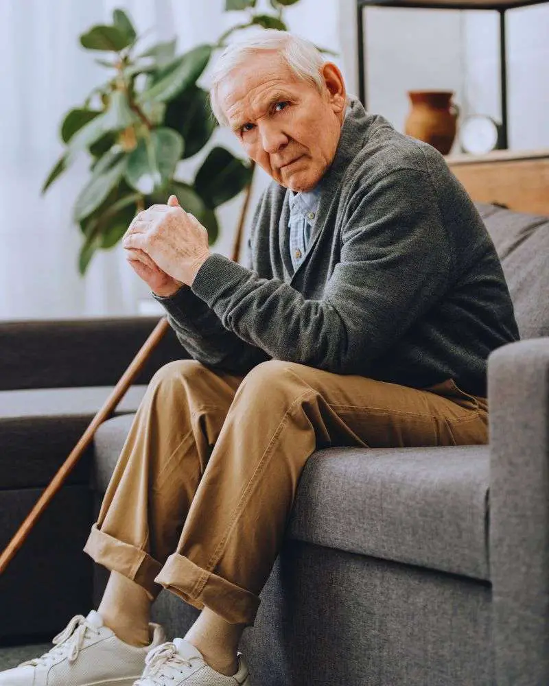 an old man sitting on a couch wondering what not to say to someone with dementia