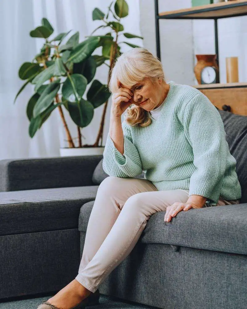 a woman sitting on a couch wondering what not to say to someone with dementia