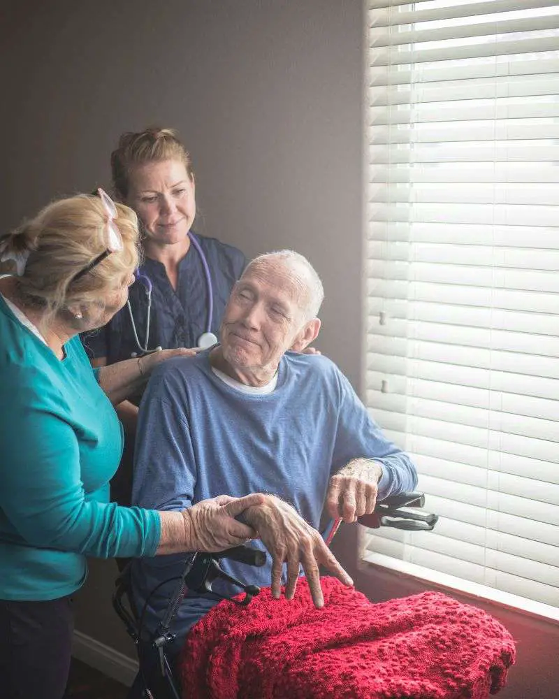 a group of people standing around a man in a wheelchair