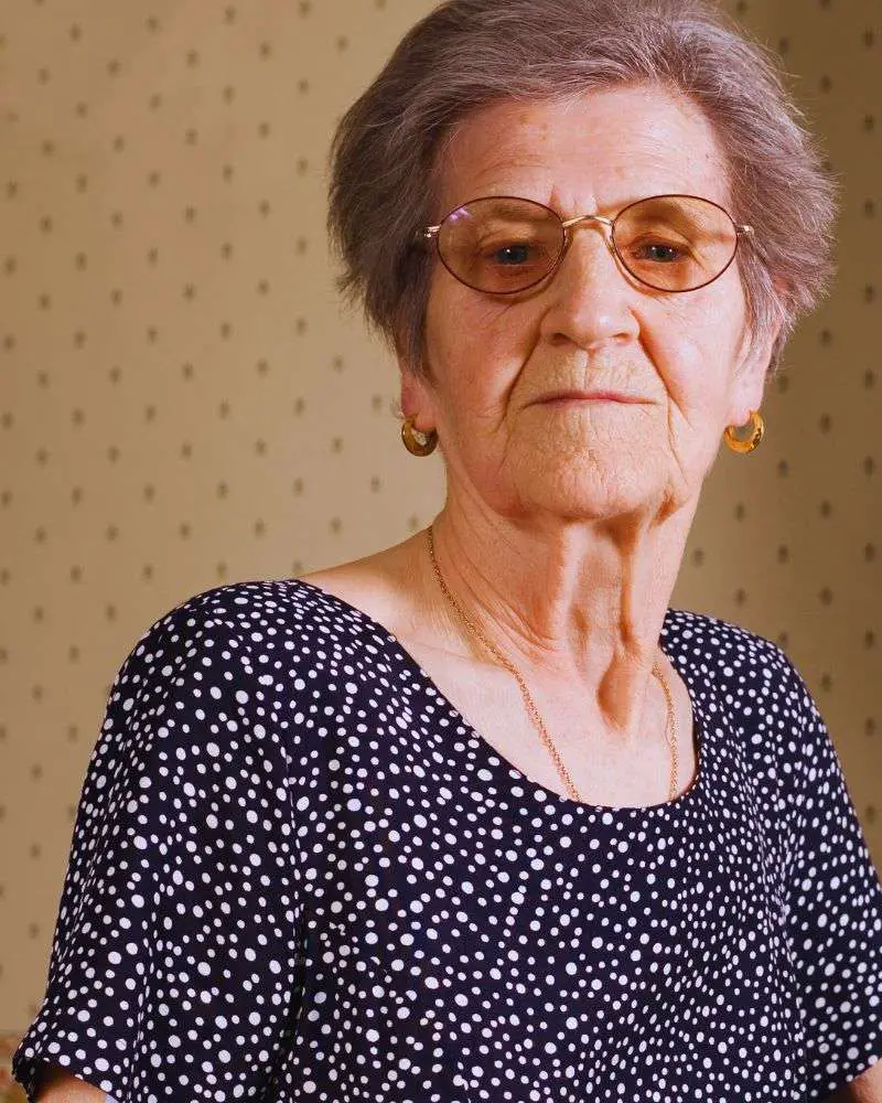 a woman wearing glasses and a polka dot dress wondering what not to say to someone with dementia