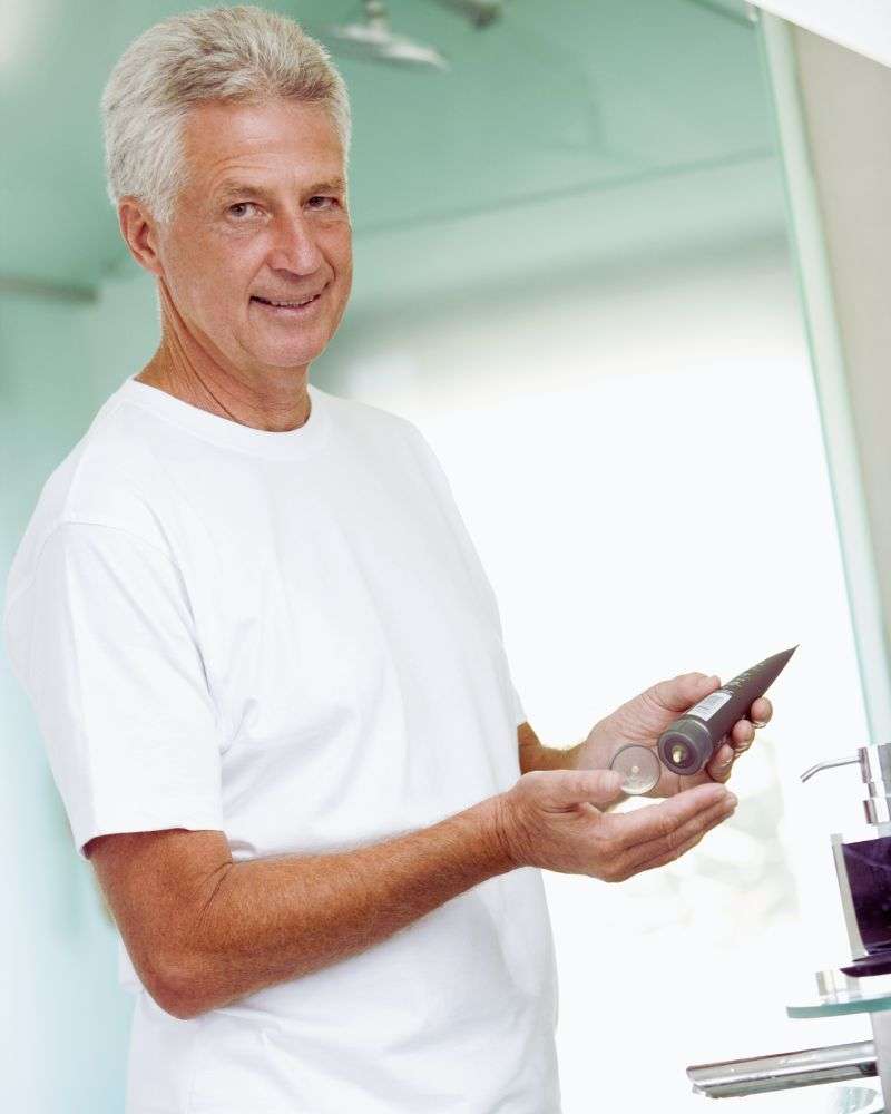 man applying best colognes for men over 50