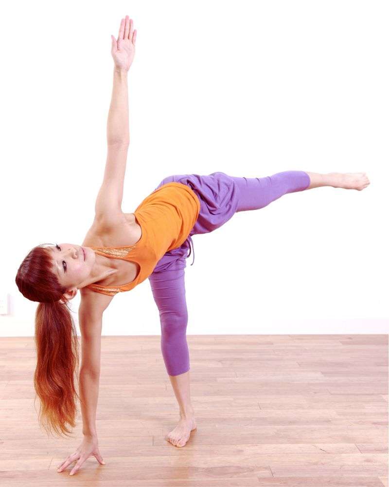 a woman doing yoga on a wood floor to demonstrate how yoga for couples over 50 can be accessible