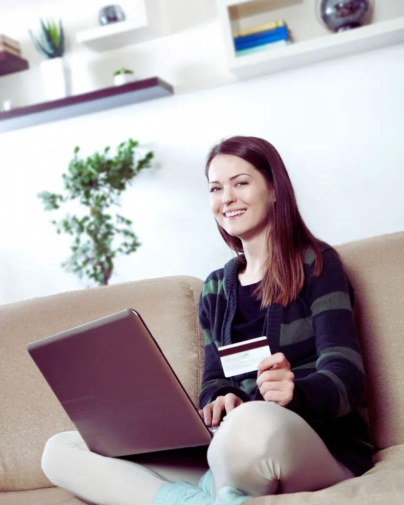 Woman sitting on a couch shopping online wondering is temu japanese or chinese before making a purchase