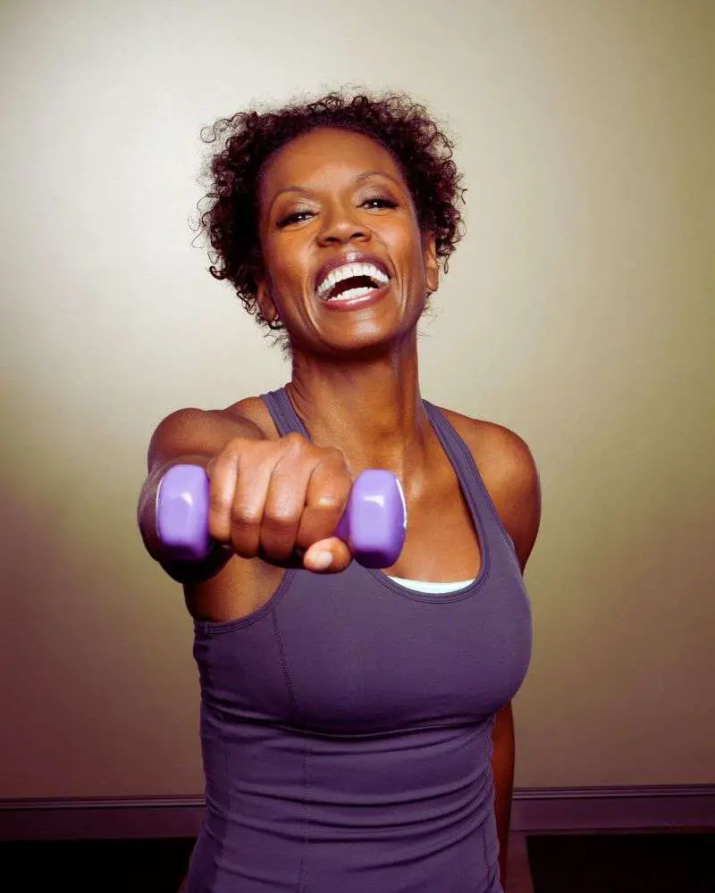 Woman lifting a dumbell to demonstrate safe 5x5 workouts for over 50 women