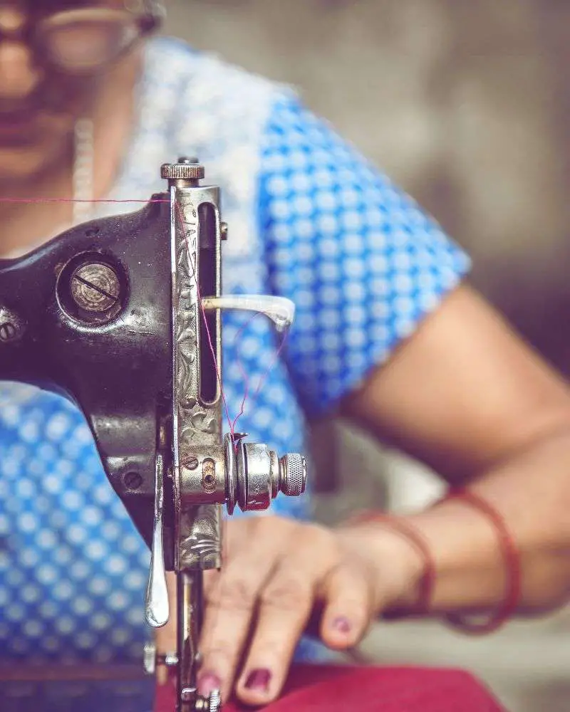 a close up of a sewing machine that an older woman is using after reading 19-best-sewing-blogs-for-over-50