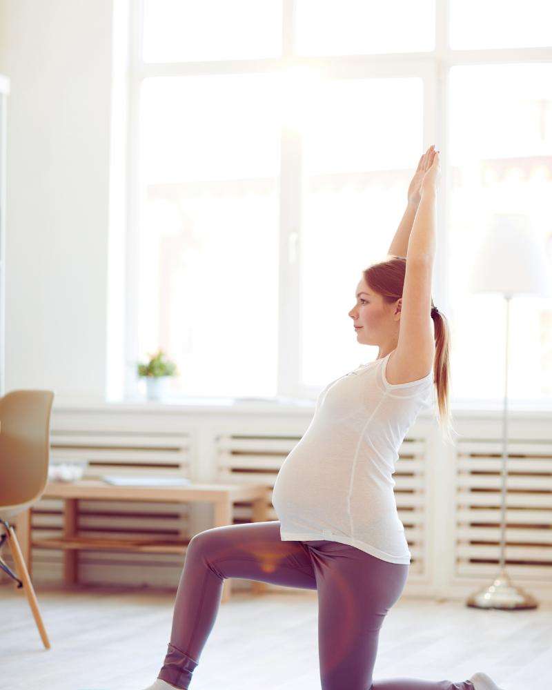 Pregnant woman doing yoga while considering pregnancy at 43 statistics 