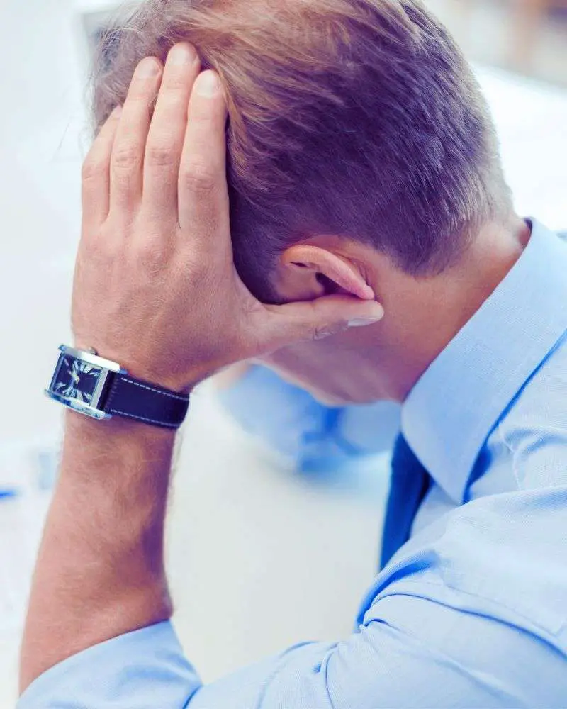 a man with his hand on his head contemplating second careers for lawyers over 50.