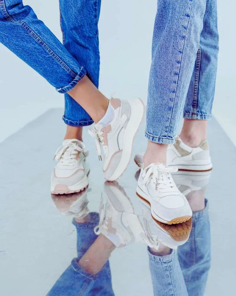 Two women in blue jeans wearing arch support sneakers for women over 50