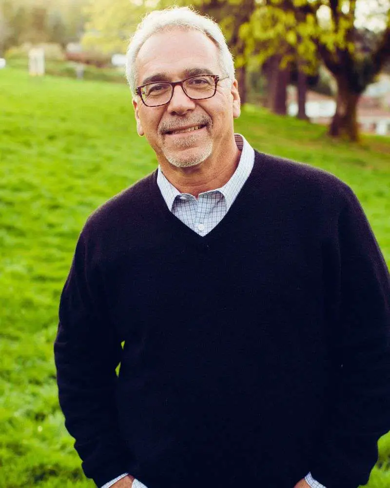 a man wearing glasses and a sweater