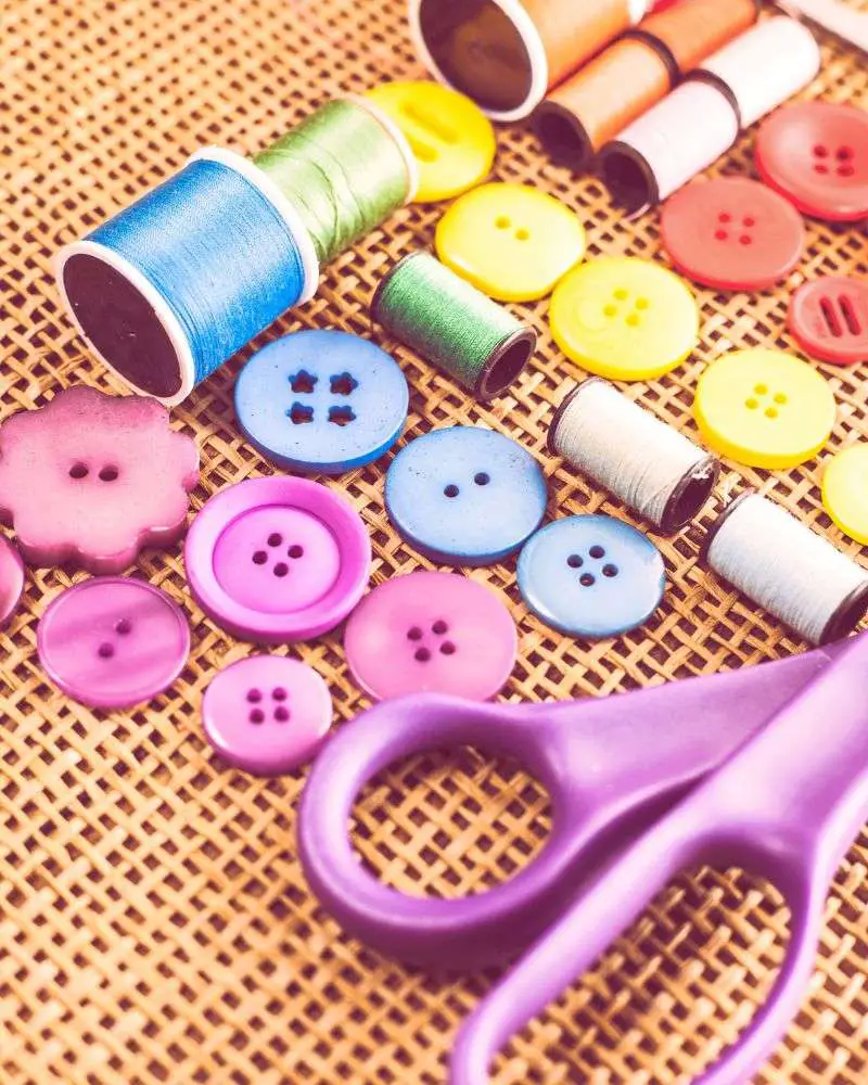 a group of sewing buttons and scissors