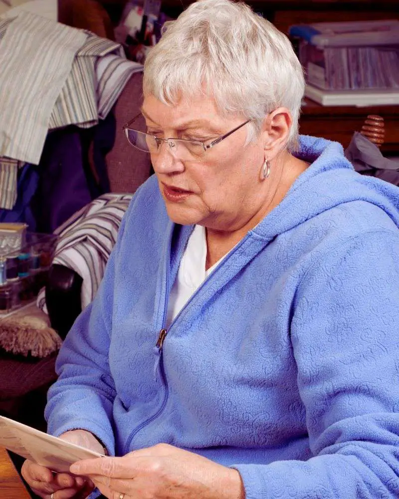 a woman reading a book on sewing after reading 19-best-sewing-blogs-for-over-50