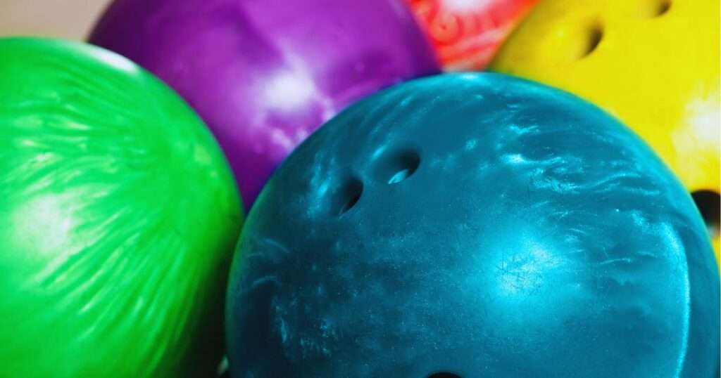 Blue, green, yellow, and purple bowling balls