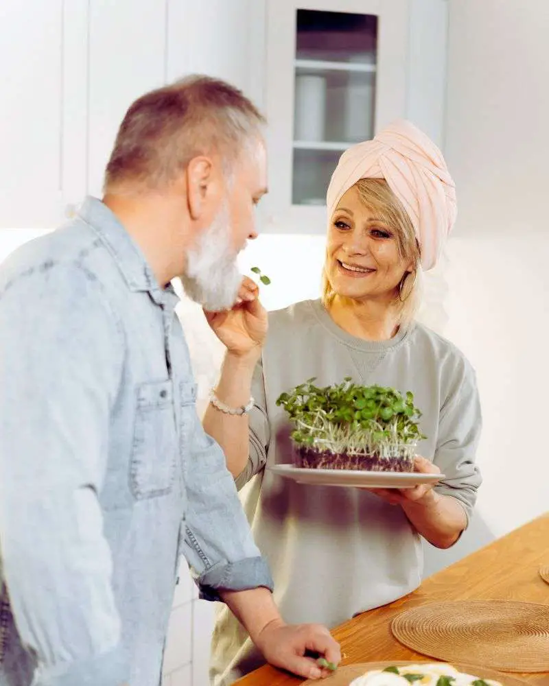 An older woman hand feeding an older man to demonstrate the different types of finger foods for the elderly