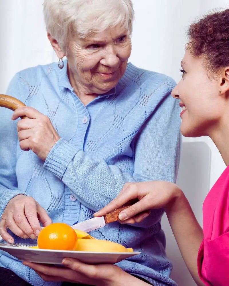 A young nurse feeding a senior orange slices to demonstrate some of many finger foods for the elderly