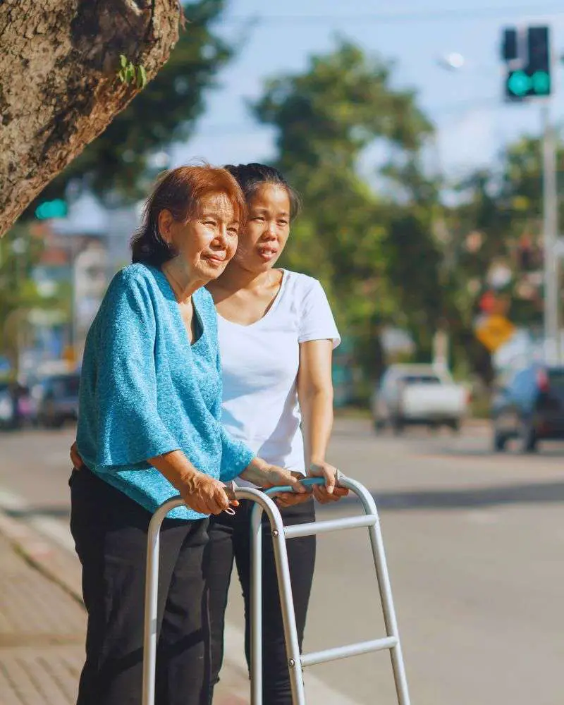 Two older women using a quad cane to get around