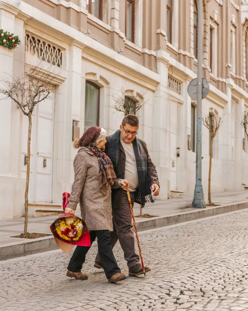 a man and woman walking down a street together after learning how to overcome nerves on a first date over 50