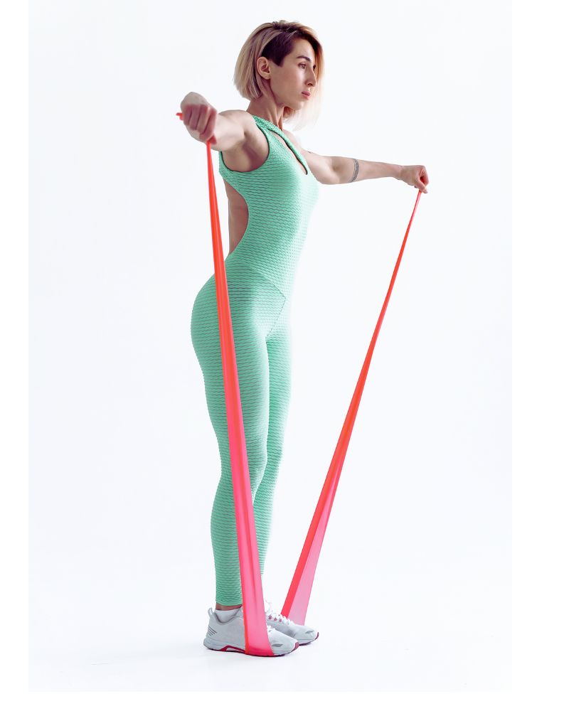 a woman in a green jumpsuit practicing Resistance Band Exercises for Over 60