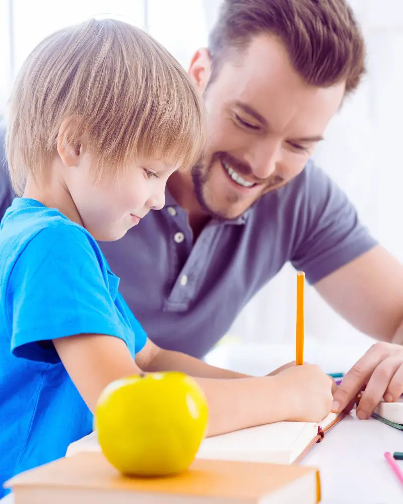 a man and child writing on a book