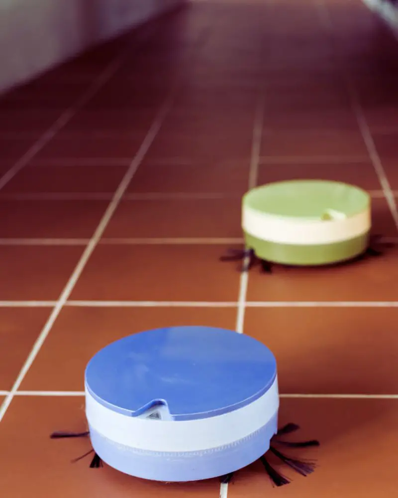 a group of circular robot vaccums on a tile floor to demonstrate Christmas gift ideas for wife over 50