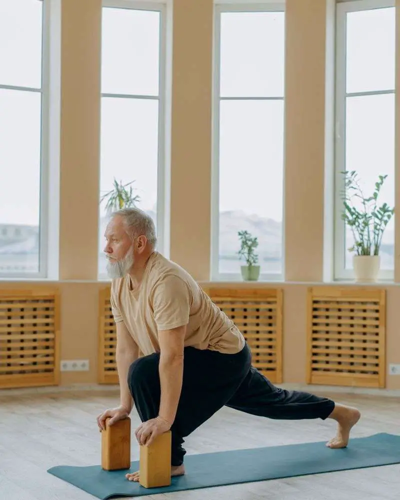 a man using blocks in one of the best yoga dvds for beginners over 50