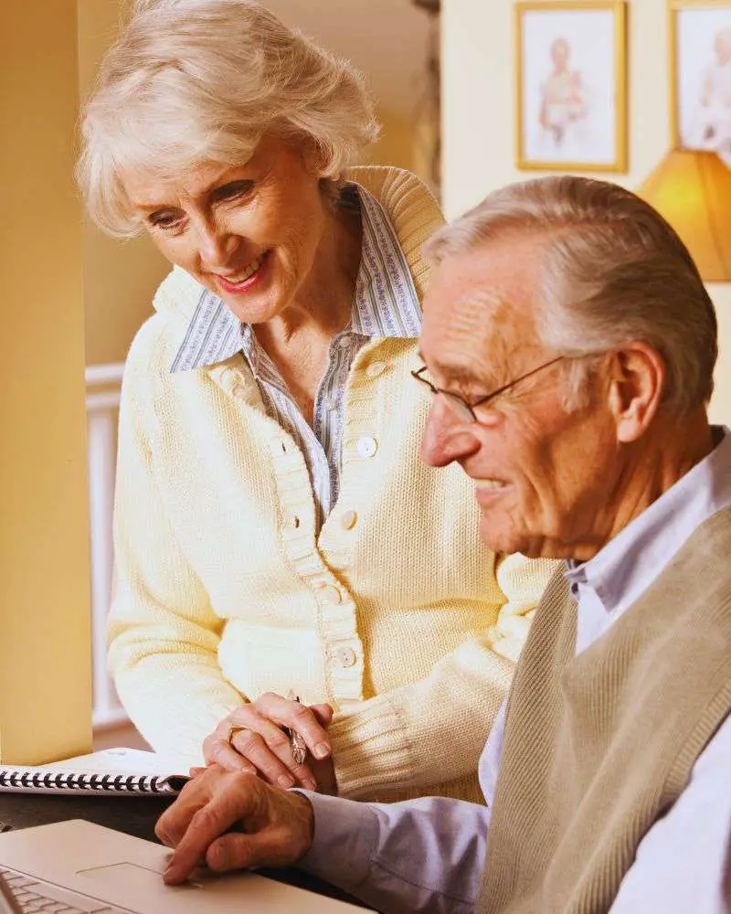 a man and woman looking at a notebook