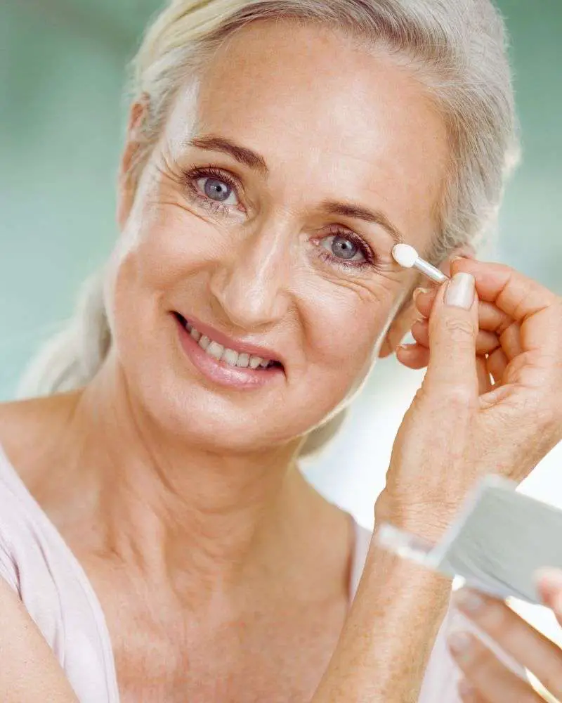 a woman putting on makeup