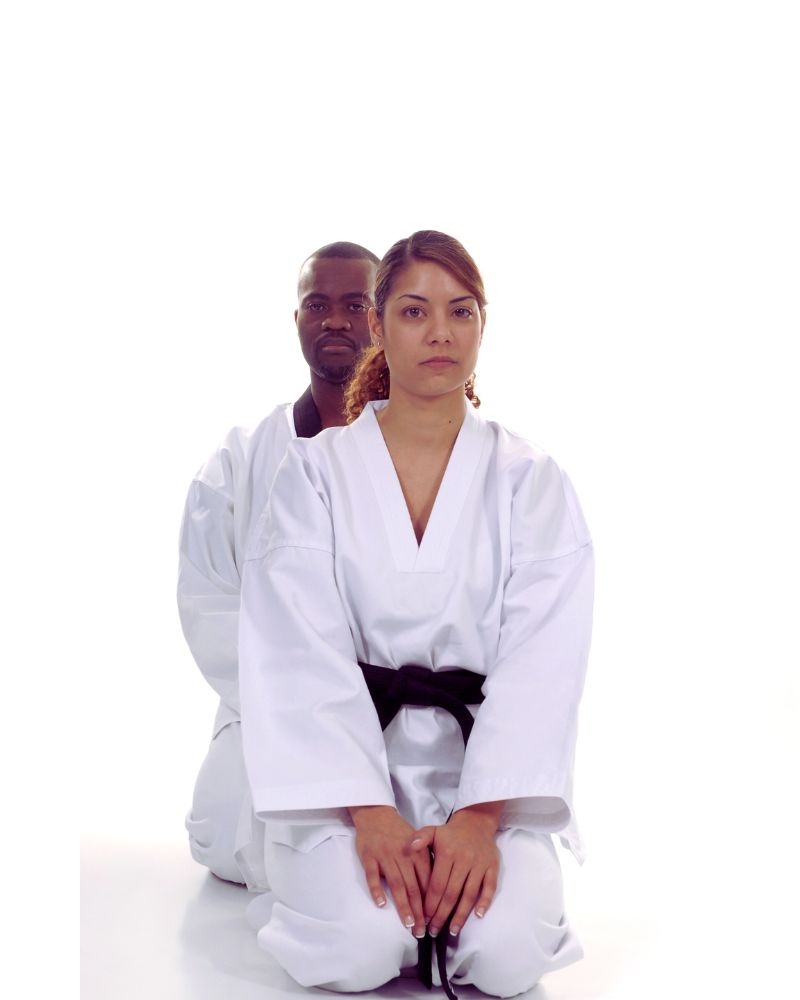 a man and woman in karate attire performing martial arts for people over 50